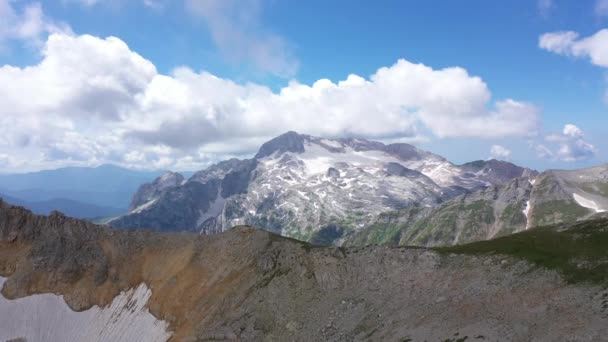 Tembakan udara dari pegunungan melawan tebing berbatu, gletser dan puncak bersalju. Menakjubkan pemandangan udara lanskap gunung. — Stok Video
