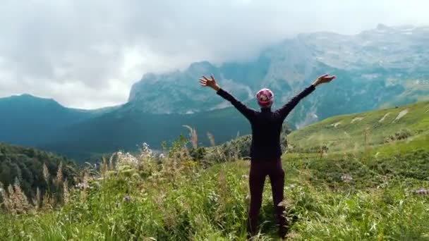 Nő turista emeli fel a kezét a hegyekben élvezi a gyönyörű kilátás és a környező vad természet. Győzelem és siker, a cél elérése. — Stock videók
