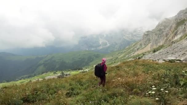 Fiatal nő hátizsák sétál a csúcs felé. Lassított. Lady túrázás a gyönyörű kaukázusi hegyekben. — Stock videók