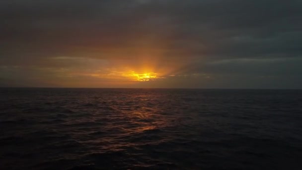 美しいカラフルな夕日に向かって海の波の上にゆっくりと飛行。海、海の美しい夜の空中ドローンショット. — ストック動画