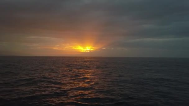Slow low flight above ocean waves towards beautiful colourful sunset. Aerial drone shot of beautiful evening on the open sea, ocean. — Stock Video