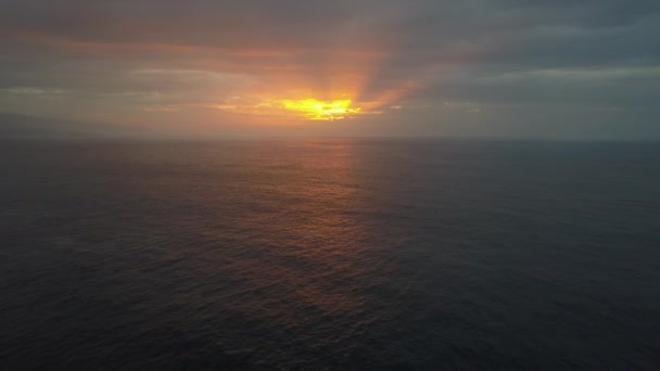 Slow backward flight above ocean waves towards beautiful colourful sunset. Aerial drone shot of beautiful evening on the open sea, ocean. — Stock Video