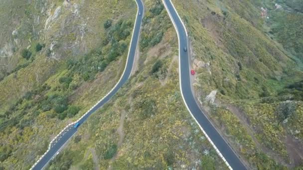 Vista aérea del tráfico en una serpentina carretera en Tenerife, España. Montañas Canarias cubiertas de plantas verdes . — Vídeo de stock