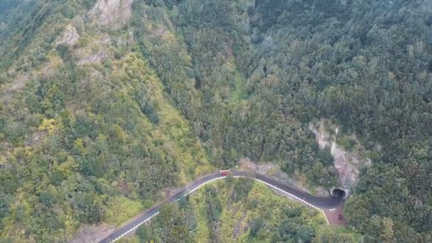 スペイン、テネリフェ島の蛇行道路上の車の航空写真。車はちょうどトンネルから出たところです. — ストック動画