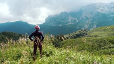 Güzel manzaranın ve çevredeki vahşi doğanın tadını çıkaran dağlarda kadın yürüyüşçü. Kayalık kayalıklara, buzullara ve karlı zirvelere karşı alp çayırları. Bir dağ manzarasının muhteşem manzarası.