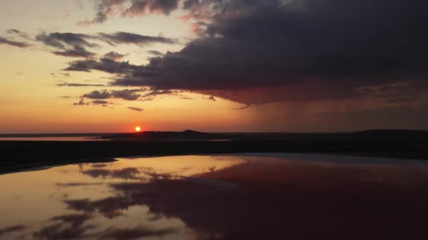 Drone lotnicze strzał słone jezioro na Krymie o dramatycznym zachodzie słońca. Oszałamiający wschód słońca nad solą Koyashsky jezioro. płaski krajobraz z góry na horyzoncie. deszcz opadający z chmury na tle. — Wideo stockowe