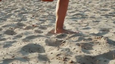 Yavaş Hareket'te kum sahilde koşan yalınayak bir kadın ayağının yan görünümü. Aktif sportif yalınayak Kadın koşu ve eğitim Trekking atış.