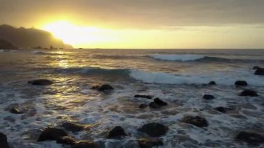 Havadan görünüm. Tenerife, Kanarya Adaları Benijo plaj yakınında kayalar üzerinde çökmesini ve güzel günbatımı ışık püskürtme Okyanus dalgaları üzerinde Uçuş.