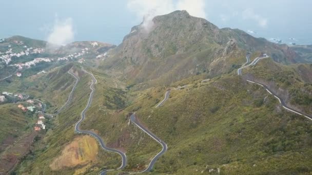 Luchtfoto van het verkeer op een serpentijnse weg in Tenerife, Spanje. Canarische bergen bedekt met groen bos. — Stockvideo
