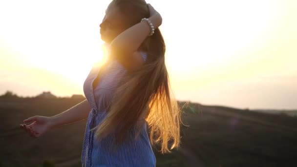 Gros plan portrait de souriante et joyeuse fille féminine regardant à la caméra dans le paysage rural. Jolie jeune femme agite ses cheveux se tournant vers la caméra. Beauté naturelle féminine au ralenti . — Video