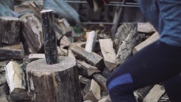 Man chops wood outdoors in slow motion. Mans hands working with ax. A man woodcutter chops tree trunks with an ax for firewood. — Stock Video