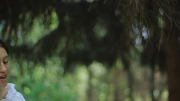 Mãe sorridente levanta seu bebê recém-nascido no ar ao ar livre no fundo de plantas verdes. Jovem mãe e criança feliz desfrutar da natureza . — Vídeo de Stock