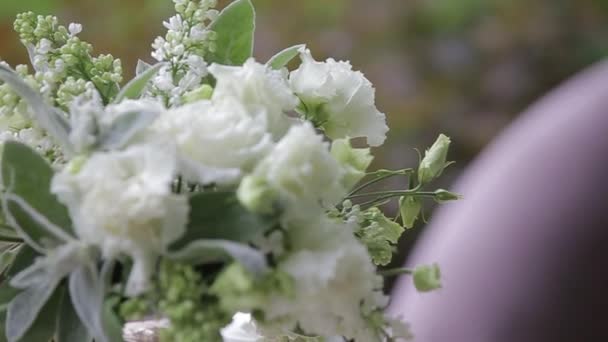 白いカップのホットティーは、花の花束で飾られた白いテーブルの上で屋外で提供. — ストック動画