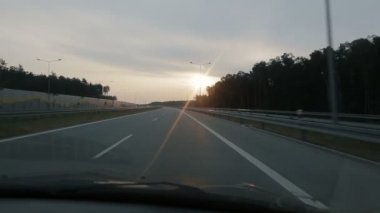 Pov gün doğumu sırasında sabah erken saatlerde geniş bir boş sabah yolu boyunca sürüş ... Bakış açısı sürüş, Polonya'da otoban üzerinde arabanın içinden görünümü.