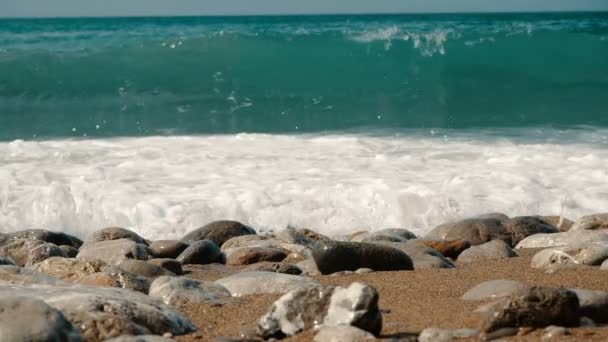 Grandes olas están cayendo sobre piedras y rociando en cámara lenta. Hermosa playa en Crimea con piedras y arena . — Vídeos de Stock