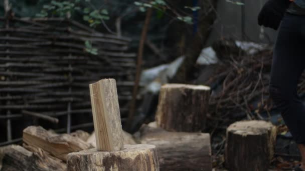 Man koteletten hout buitenshuis in slow motion. Mans handen werken met AX. Een man houtsnijder koteletten boomstammen met een bijl voor brandhout. — Stockvideo
