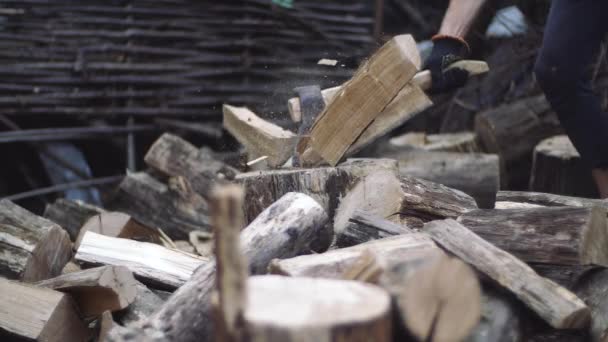 Un leñador hombre corta troncos de árbol con un hacha para leña. Manos de hombre trabajando con hacha. El hombre corta madera al aire libre en cámara lenta . — Vídeos de Stock