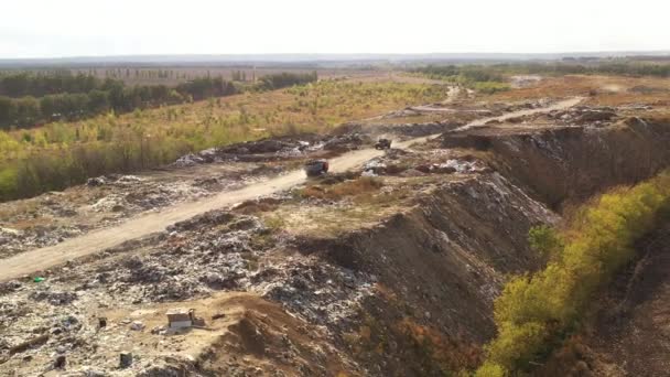 Luchtfoto van grote vuilnishoop op de sorteerplaats. Vrachtwagens brengen afval naar een vuilnisbelt in de vuilnisbelt. Milieuverontreiniging door consumptiegoederen. — Stockvideo