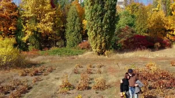 Przód odprowadzając fotografię żonatych starszych par trzymających się za ręce i spacerujących po lesie z pięknymi kolorowymi drzewami rano w sezonie jesiennym. Romantyczny spacer na emeryturę wśród drzew. — Wideo stockowe