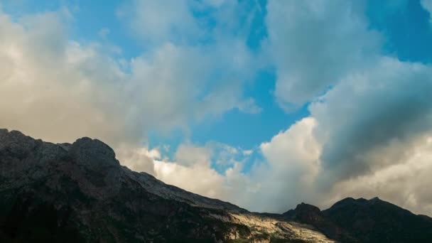 Αεροφωτογραφία του βουνού Adygea κάτω από μεγάλα σύννεφα σε καθαρό ουρανό την άνοιξη στον Καύκασο της Ρωσίας. Όμορφη πανοραμική βολή στην κορυφή του βράχου κάτω από τον ήλιο και τα σύννεφα. Timelapse της φύσης, κορυφαία άποψη. — Αρχείο Βίντεο