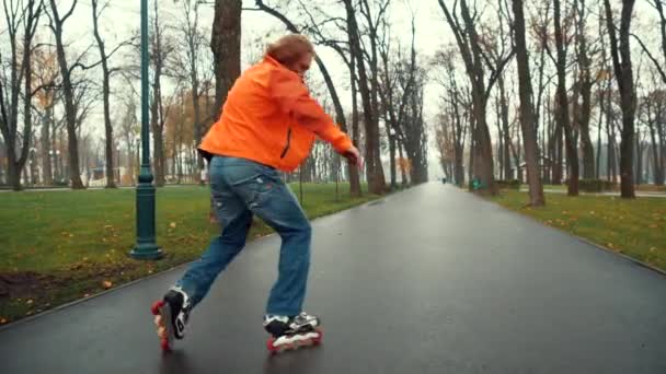 経験豊富なひげそりの男性スケーター技術的かつ仮想春に木や草の間で公園の路地のアスファルトの道路上で複雑なUターンやトリックを実行します。週末のアクティブレジャーコンセプト. — ストック動画