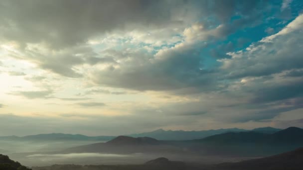 Bovenaanzicht van bewegende dichte wolken, van waaruit de stralen van de zon schijnen over de prachtige bergen van de Kaukasus in het voorjaar in de schemering. Timelapse natuur in een prachtig landschap, Adygea, Rusland. — Stockvideo