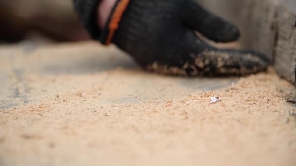 Mans mão em trabalho luva esmaga serragem de mesa em câmara depois de serrar placa com circular, close-up vista em câmera lenta. A serradura voa no ar. Conceito de reparação de estrutura de construção de habitação . — Vídeo de Stock