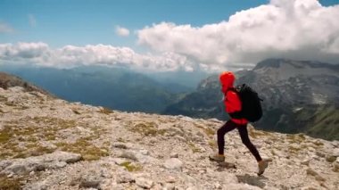 Sırt çantalı kadın turist Kafkas dağının zirvesine tırmanıyor ve güzel manzaraları izlemekten zevk alıyor, Rusya 'nın Aygea şehrinde el ele tutuşuyor. Aktif yaşam tarzı ve yürüyüş kavramı.