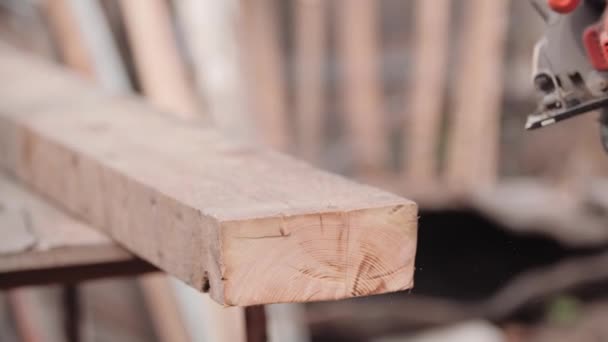 Close-up view in slow motion of unidentified worker in working gloves, hand-stroking sawn place of board and crushing sawdust after work with grinder. Woodwork using circular. Concept of frame housing — Stock Video
