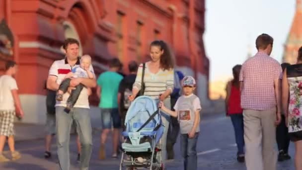 俄罗斯，莫斯科- 2019年5月6日：一家人在人群中走在克里姆林宫附近。妈妈带着婴儿车，孩子和爸爸带着孩子在首都市中心散步。室外休闲活动. — 图库视频影像