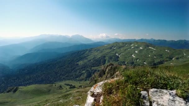 Widok rano z kamienia pięknej zielonej doliny z dzikim lasem i sylwetki górskie w słonecznej pogodzie pod czystym niebem w krajobrazie lotniczym. Wspaniała przyroda Kaukazu, Adygea, Rosja. — Wideo stockowe
