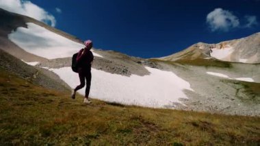 Tebeşir dağının yamacından inen aktif kadın turistin yaz aylarında yürüyüş yapan bacakları ve sırt çantasıyla en alttaki görüntüsü. Aktif yaşam tarzı spor turizmi, kamp ve seyahat kavramı.