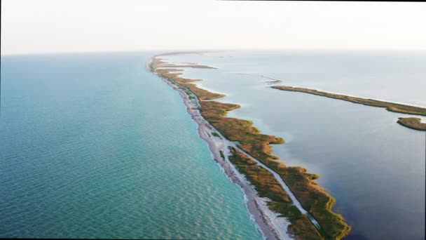 Vista panorâmica aérea da paisagem de belo cuspo na Crimeia no Mar Negro durante o dia em tempo ensolarado no verão. Voo sobre lugar maravilhoso de reserva natural para descanso, Ucrânia. Manhã sobre o oceano . — Vídeo de Stock