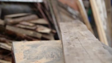 Ağır çekimde testereyle kesmek için kalın tahtayı masaüstünde oynatmak. Birisi dairesel makineyle kesmek için bir parça odun itiyor. Çerçeve konut inşaatı kavramı.