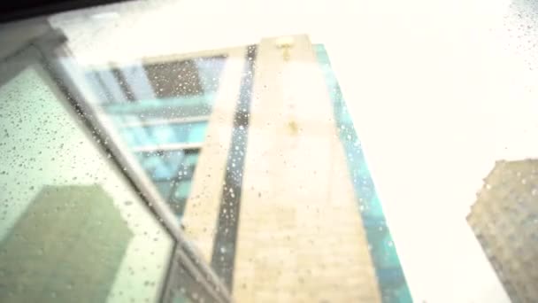 Üveg eső alatt az átmenet a tekintélyes és drága szálloda Harkov Palace Kharkov, Ukrajna. A folyosó nedves üvege az épületben, amelyen keresztül az utca látható. — Stock videók