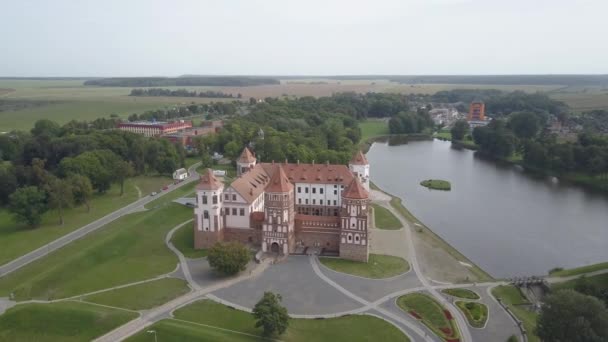 Αριστούργημα αρχιτεκτονικής της Λευκορωσίας - Mir Castle μεταξύ των λιμνών και των πάρκων, εναέρια άποψη. Πετώντας πάνω από το διάσημο και ιστορικό κάστρο Nosvizh σε ζεστό ηλιόλουστο καιρό στην παλιά πόλη της Nesvizh, Λευκορωσία. — Αρχείο Βίντεο