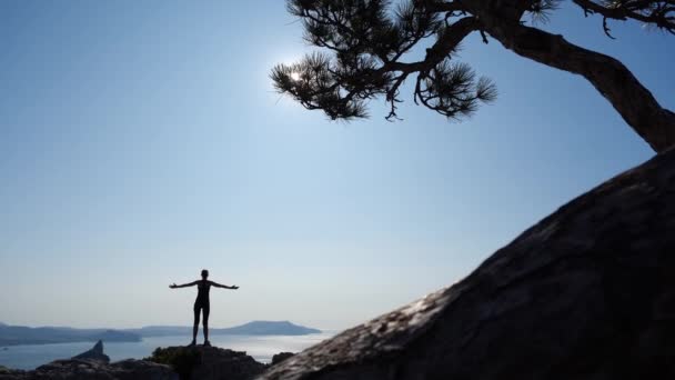 Mujer atleta conquistó una alta montaña Karaul-Oba y disfruta de una hermosa vista del sol y el mar Negro en cámara lenta, vista trasera. Pasatiempo activo, viajes y turismo deportivo. concepto de estilo de vida saludable . — Vídeos de Stock