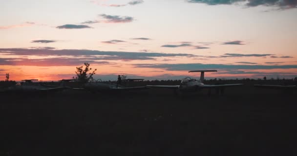 Vista a distancia de la silueta del niño corriendo a lo largo de los combatientes militares soviéticos y otro niño corriendo paralelo al perro en tierra en el aeropuerto contra el telón de fondo de la puesta de sol en cámara lenta. Tour en avión . — Vídeo de stock