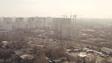 Ukrayna 'nın Kharkov kentinin hava görüntüsü. Konut binaları, garajlar, arabalar, yeni modern ofis binaları, uçan kuşlar ve vinçler. Gündüz şehir panoraması