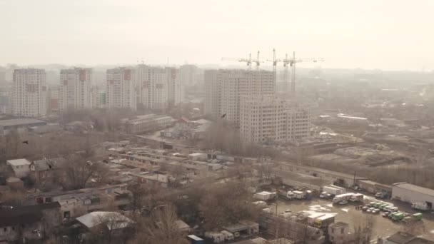 Letecký snímek rozvojového města Charkov, Ukrajina. Pohled z výšky obytných budov, garáží, aut, nových moderních kancelářských budov, létajících ptáků a jeřábů. Panorama města během dne