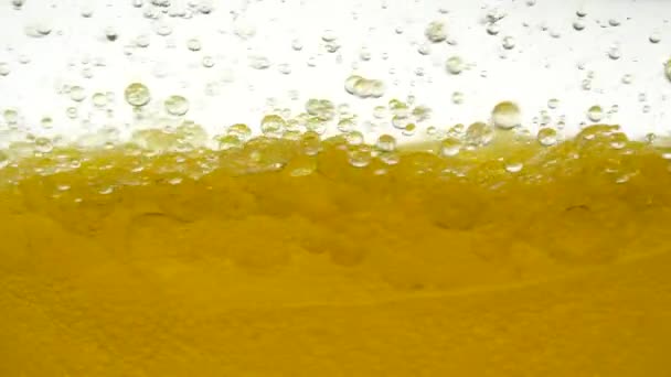 L'olio di girasole giallo è mescolato con acqua, non si dissolve. Le lampadine a bolle d'aria galleggiano nei liquidi creando fantasie, texture e sfondi. Colpo al rallentatore del liquido dell'olio da versare. Vitamina E sana — Video Stock
