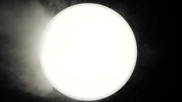 Une forte fumée souffle sur une boule blanche sur un fond sombre. Quelqu'un donne de la vapeur à un cercle mystique lumineux dans un fond noir. La balle est similaire à la lune et provoque diverses associations. — Video