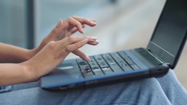 Kvinnliga händer unga kvinna skriva sms på laptop ligger på flickor knä f i jeans, närbild. Graciösa fingrar av kvinna programmerare med manikyr arbete vid datorn utomhus i urban stad — Stockvideo