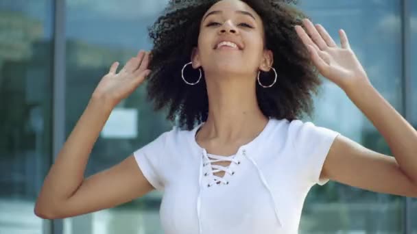 Jovem mulher étnica americana ativa pulando dançando na rua da cidade, ao ar livre. Menina estudante feliz ter emoções divertidas gosta de jogar atividade engraçada, câmera lenta. Conceito de estilo de vida moderno, close up . — Vídeo de Stock