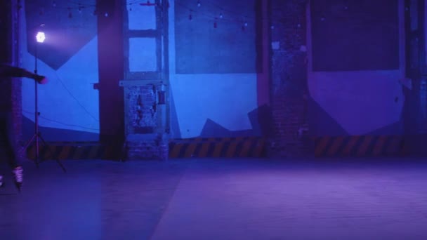 2人の若い男性のデュエットは、同時に明るいピンクと青の照明とブレーキの下でステージ上でプロのスケート、男に焦点を当てたサイドビュー。スケーターからのクールなパフォーマンス. — ストック動画