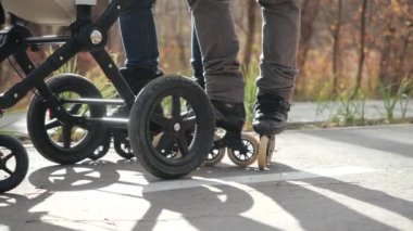 Ebeveynler bebekle bebek arabasında yürür, sonbaharda paten kayar, tekerlekli sandalyelerle bacaklara odaklanırlar. İki yetişkin, bir çocukla parkta paten kayarak bir gün geçirir..