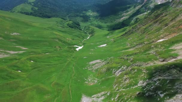 Picos vista aérea de Oshten e Fisht montanhas de verde caucasiano vale deserto coberto grama, rio, pedras de neve. Fabuloso desfiladeiro de montanha, Adygea, Rússia. Salvando ecologia natureza, reservas de mundos — Vídeo de Stock