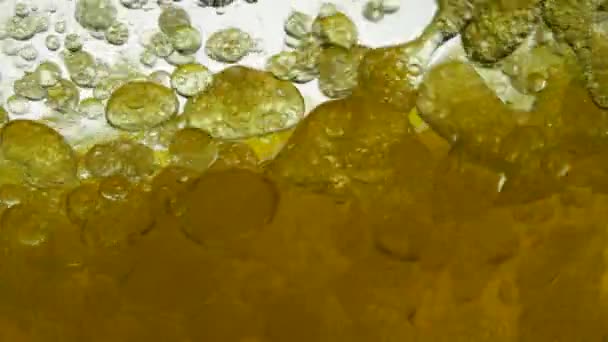 Aceite de motor de la máquina mezclado con agua, no disolver. Las bombillas de aire de burbujas flotan en líquidos creando patrones, texturas y fondos elegantes. Lento movimiento del líquido de aceite lubricante de verter — Vídeo de stock