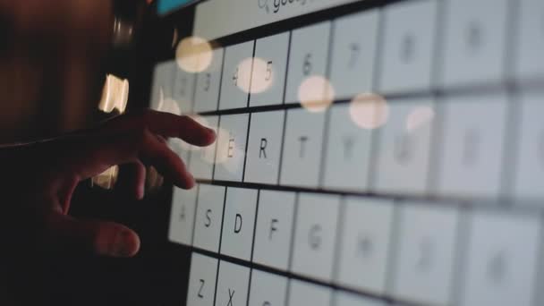 Una mano maschile fa clic sulle lettere inglesi sul touch screen del terminale con un dito, digitando. Tecnologia elettronica moderna. Un uomo la sera utilizza una ricerca in un'applicazione mobile. — Video Stock