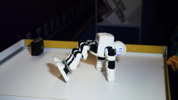 Харьков, Украина - 09 ноября 2019 года: робот UBTECH поднимается из-за стола на выставке, крупным планом, интеллектуальными технологиями. Футуристическая гуманоидная игрушка, современные технологии. — стоковое видео
